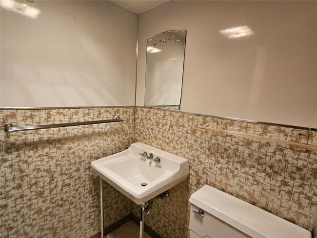 Half bath featuring a sink, toilet, and wainscoting | Image 21