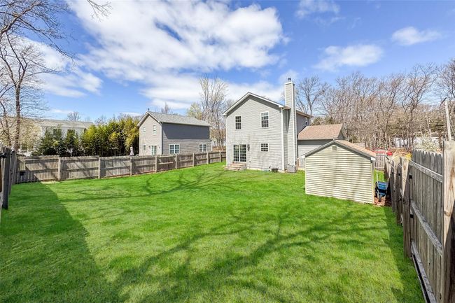 View of yard featuring a fenced backyard, an outdoor structure, a shed, and entry steps | Image 29