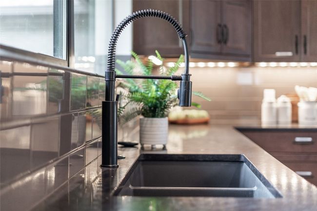 Fully remodeled, this gorgeous modern kitchen comes loaded with desirable modern finishes including built-in stainless steel appliances, granite countertops, subway tile backsplash, and custom cabinetry. | Image 19