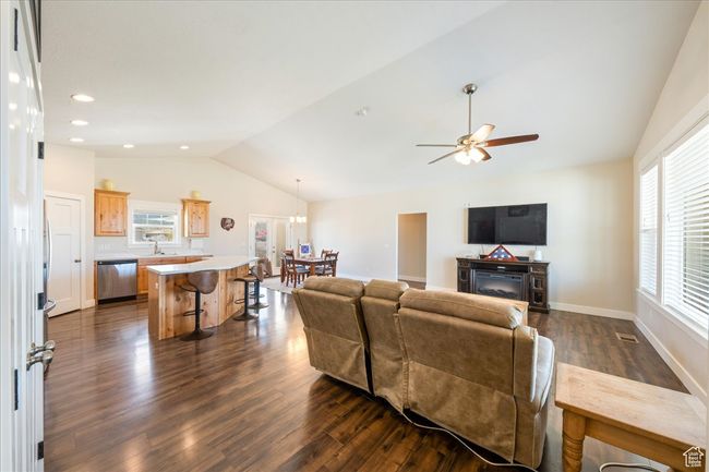 Living area featuring baseboards, recessed lighting, lofted ceiling, ceiling fan, and dark wood-type flooring | Image 9