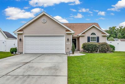 Ranch-style home featuring a front lawn and a garage | Image 1