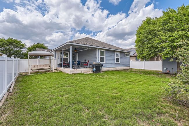 Rear view of house with a gazebo, a patio area, a lawn, a ceiling fan, and a fenced backyard | Image 25