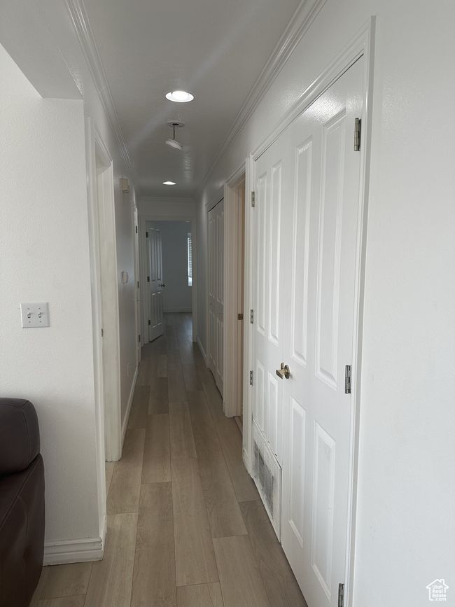 Hallway with light wood-style floors, crown molding, and recessed lighting | Image 5