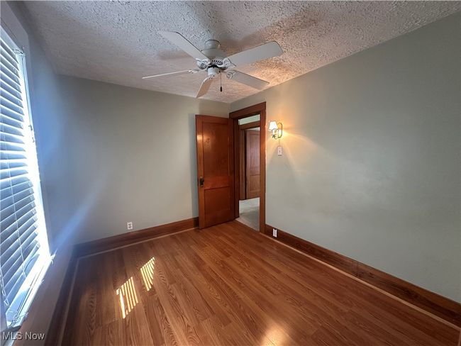 Unfurnished room with ceiling fan, baseboards, a textured ceiling, and light wood-type flooring | Image 19