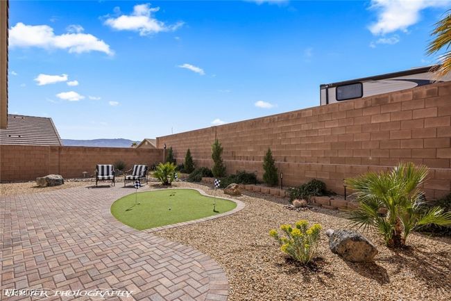 Fenced backyard featuring a putting green and a patio area | Image 55