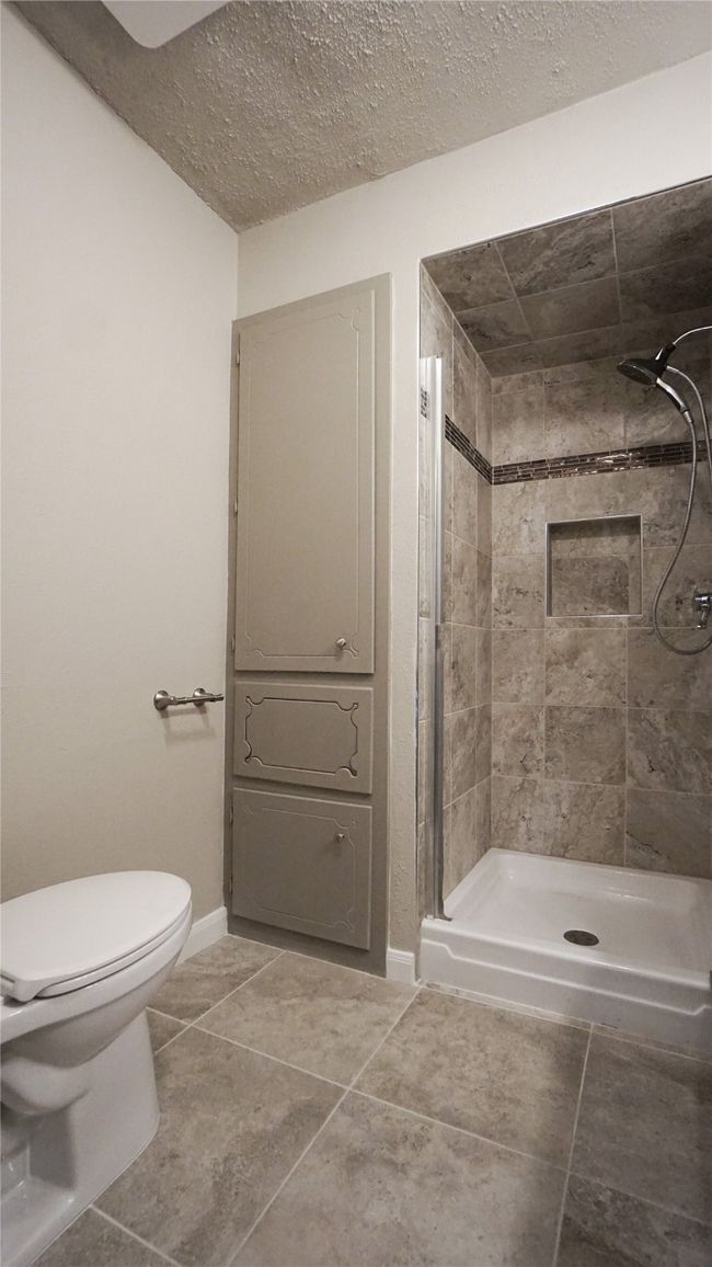 The primary bathroom features a great linen closet with a laundry drop | Image 16