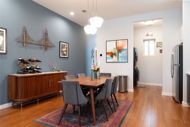 Dining room featuring stacked washing machine and dryer, wood finished floors, and recessed lighting | Image 28