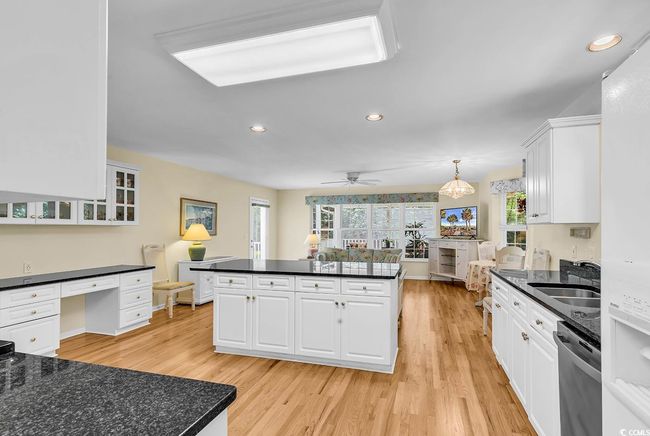 Kitchen featuring dishwasher, dark countertops, recessed lighting, light wood finished floors, and white cabinets | Image 24