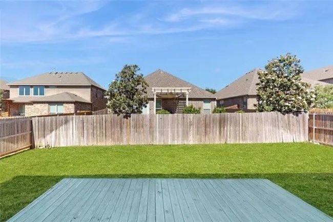 Fenced backyard with a wooden deck | Image 21