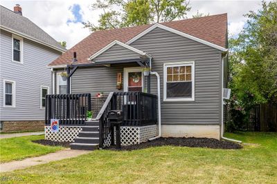 View of front of home with a wooden deck and a front lawn | Image 2