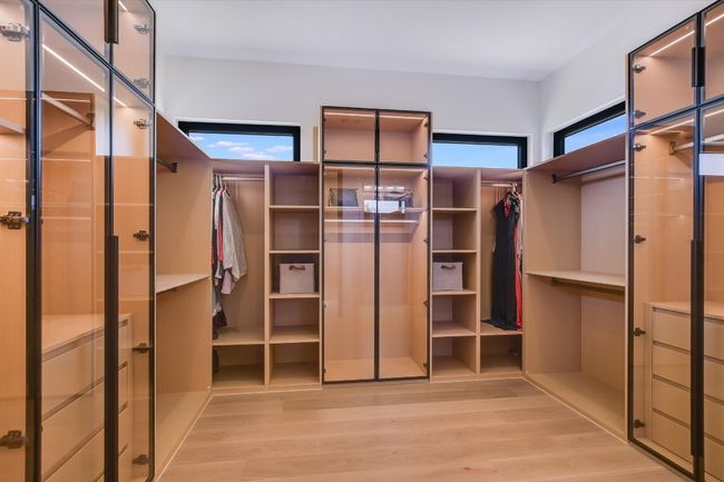 Walk in custom closet featuring light wood-type flooring, lots of customized storage for your wardrobe | Image 25
