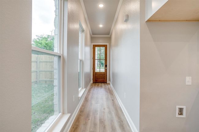 Doorway featuring crown molding, baseboards, and light wood-style flooring | Image 6