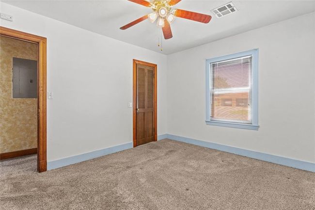 Carpeted spare room with ceiling fan and electric panel | Image 17