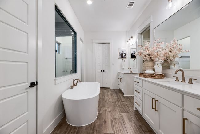 Full bath featuring baseboards, wood finished floors, two vanities, and a freestanding bath | Image 24