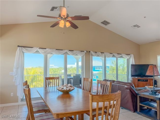 Dining area featuring ceiling fan, visible vents, vaulted ceiling, and light tile patterned floors | Image 21