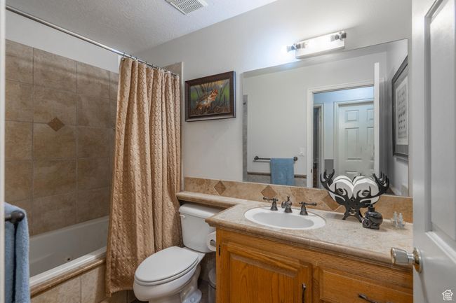 Bathroom featuring vanity, tiled shower / bath combo, and a textured ceiling | Image 40