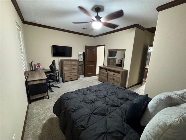 Bedroom featuring carpet, ornamental molding, an office area, and a ceiling fan | Image 18