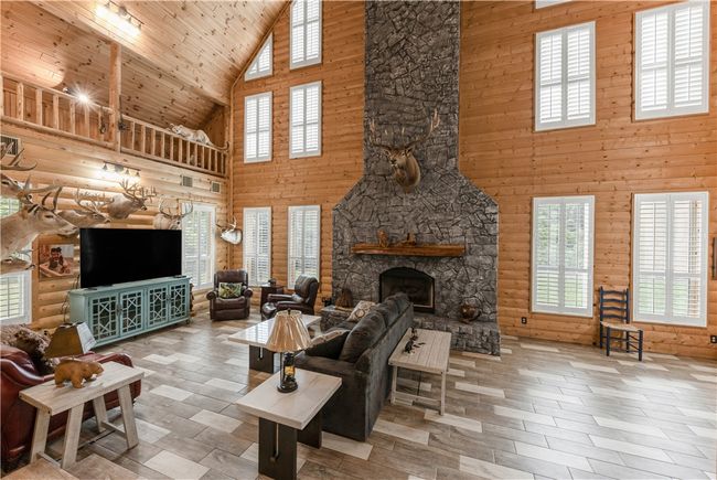 Living room featuring high vaulted ceiling, plenty of natural light, a fireplace, and wooden ceiling | Image 7