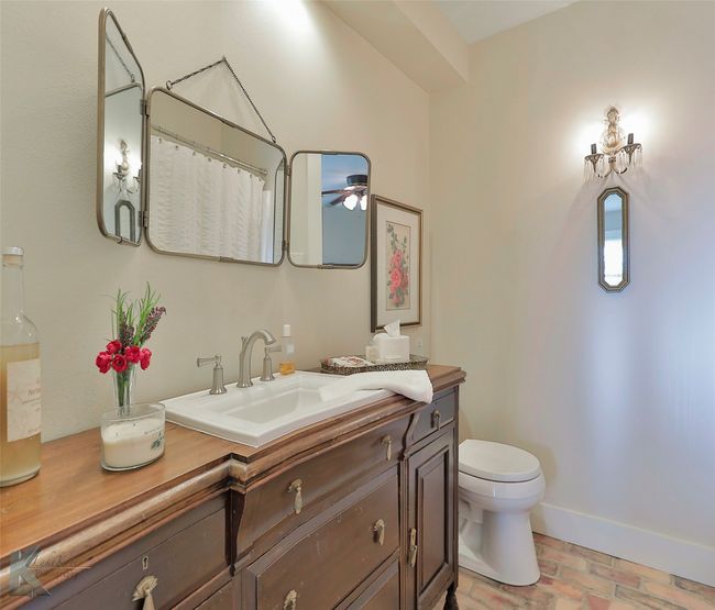 Bathroom featuring brick flooring, vanity, a ceiling fan, and curtained shower | Image 23