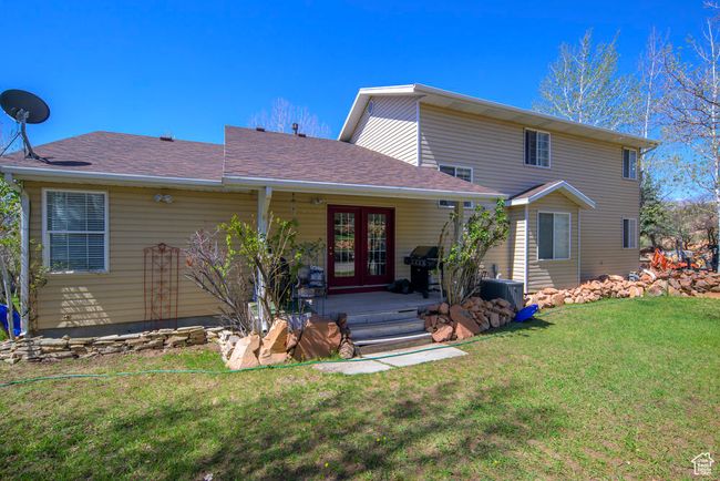 View of front facade with central AC unit, a front lawn, roof with shingles, and french doors | Image 48