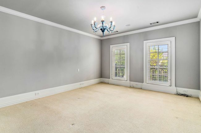 Empty room with carpet flooring, a chandelier, and ornamental molding | Image 35