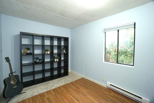 Unfurnished room featuring baseboard heating, wood finished floors, and a textured ceiling | Image 13