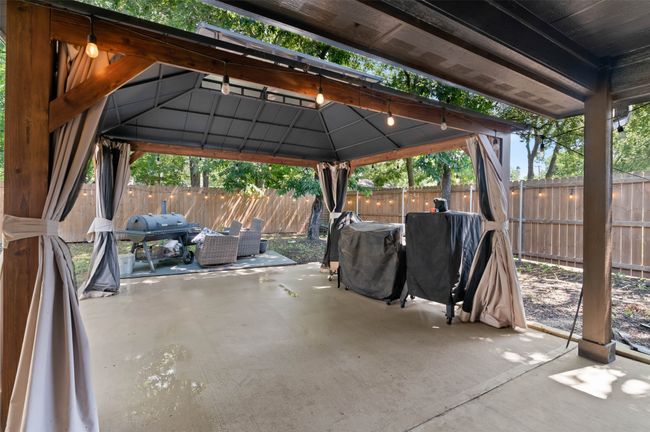 Fenced backyard featuring a gazebo, a patio area, and a grill | Image 21