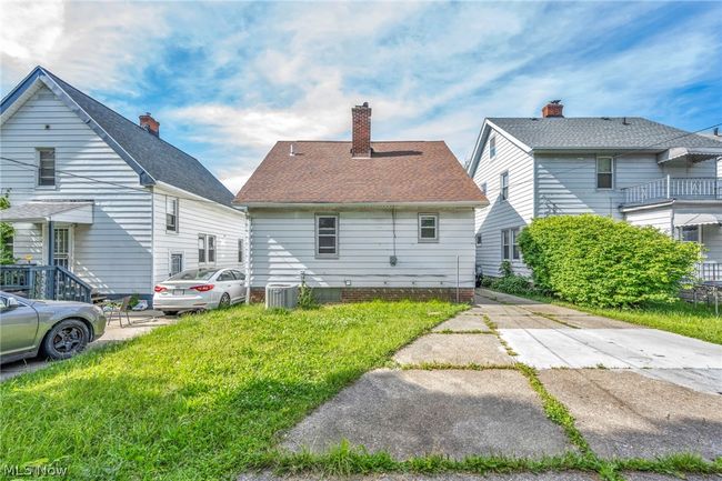 Rear view of house with a yard, a balcony, and central air condition unit | Image 4
