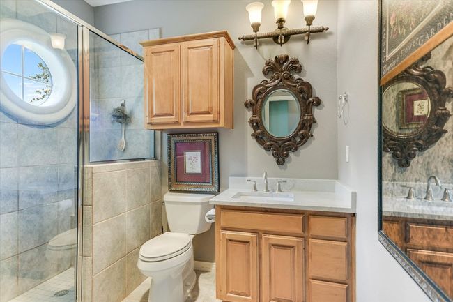 Bathroom featuring toilet, vanity, and a shower stall | Image 19