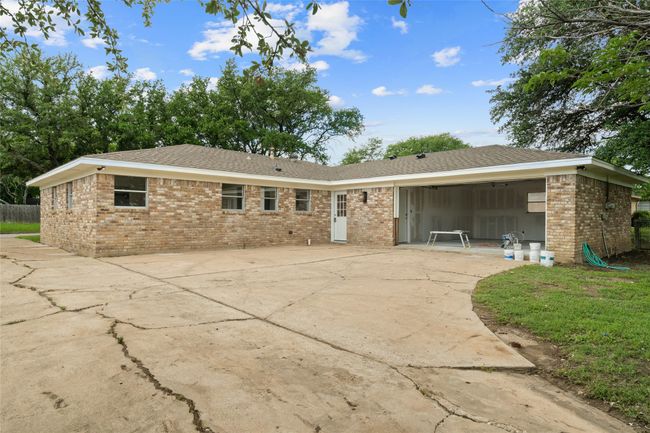 Rear view of house with brick siding, concrete driveway, and roof with shingles | Image 27