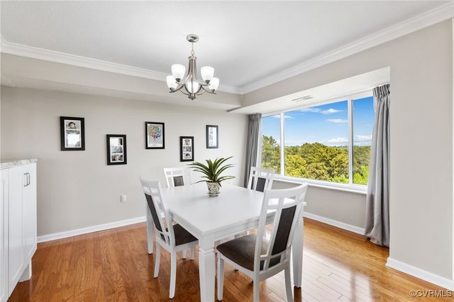 Dining space featuring light wood finished floors, an inviting chandelier, crown molding, visible vents, and baseboards | Image 6