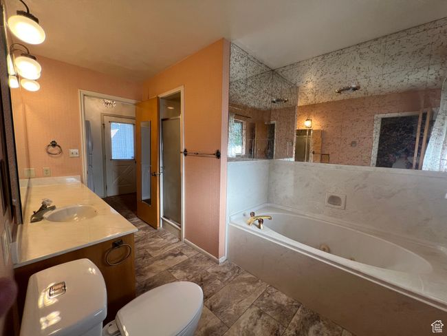 Full bathroom featuring a stall shower, a whirlpool tub, vanity and a new Bidet toilet seat. | Image 16