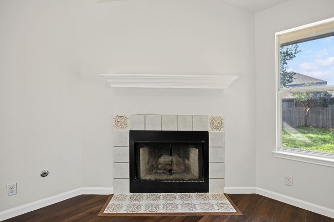 Detailed view of a tile fireplace and wood finished floors | Image 6