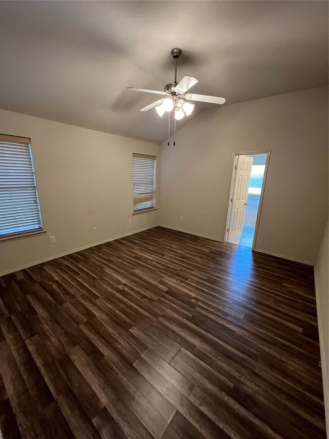 Spare room with dark wood-style flooring, vaulted ceiling, and a ceiling fan | Image 32