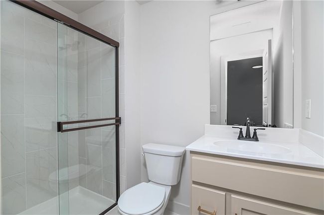 Bathroom featuring vanity, a shower with shower door, and toilet | Image 37
