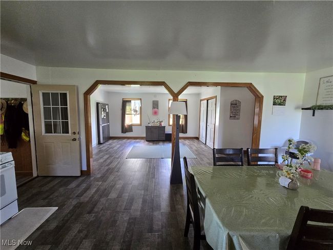 Dining area with arched walkways, dark wood-style floors, and baseboards | Image 12