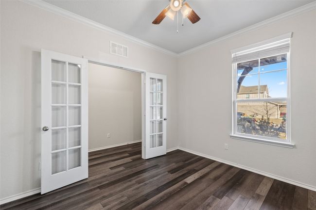 office featuring crown molding, laminate / wood-style flooring, ceiling fan, and french doors | Image 13