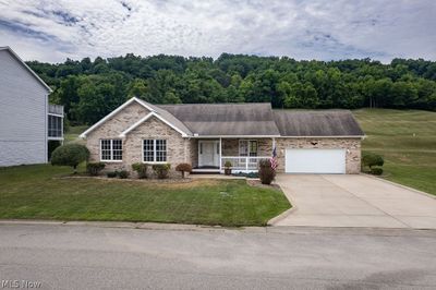 View of front of home featuring a garage, a front yard, and covered porch | Image 1