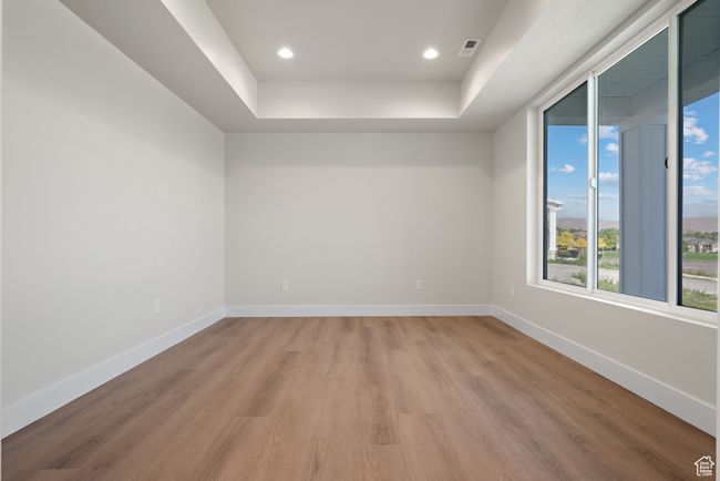 Spare room with light wood finished floors, a raised ceiling, and recessed lighting | Image 4