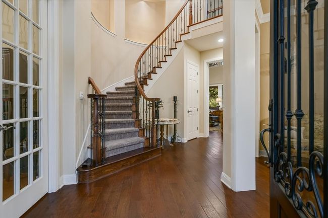 Grand foyer with hardwood floors, a towering 2 story ceiling, and sweeping stairway | Image 5