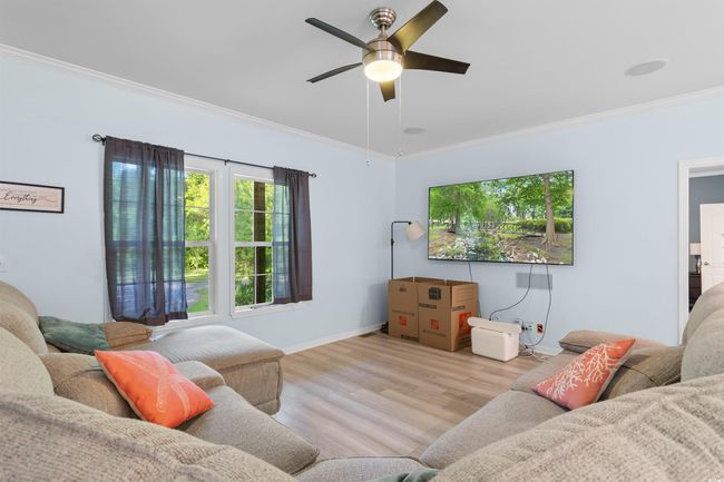 Living area featuring ornamental molding, wood finished floors, a ceiling fan, and baseboards | Image 10