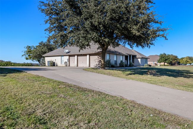 Ranch-style home with a garage, a front yard, and concrete driveway | Image 6