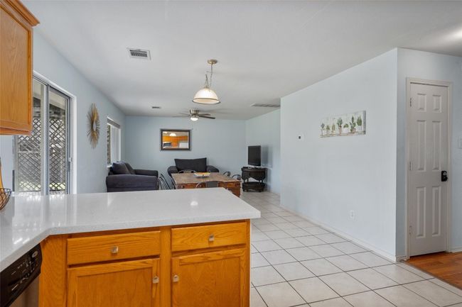 Kitchen featuring light tile patterned floors, light countertops, visible vents, open floor plan, and a peninsula | Image 6
