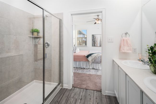 Bathroom featuring a shower stall, a ceiling fan, connected bathroom, wood finished floors, and double vanity | Image 16