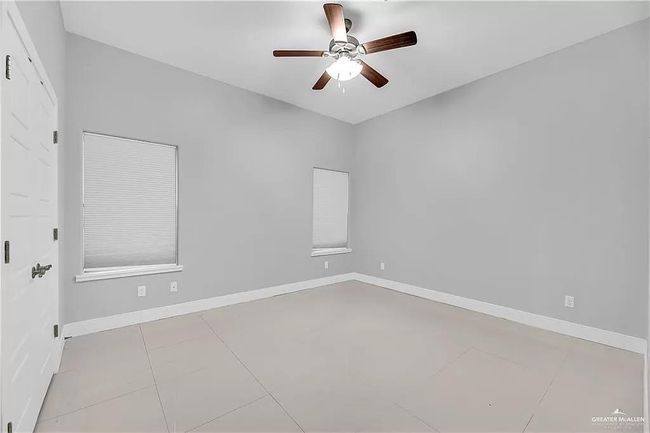 Spare room with ceiling fan and tile patterned flooring | Image 7