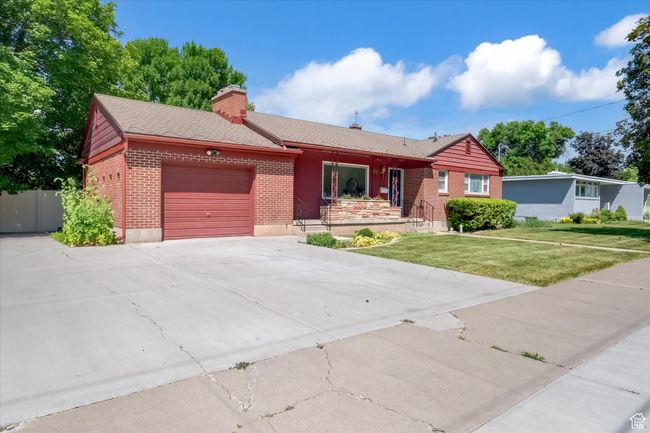 Single story home with brick siding, a garage, concrete driveway, a chimney, and a front lawn | Image 39