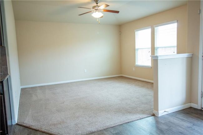 Empty room with ceiling fan, wood finished floors, and carpet floors | Image 11