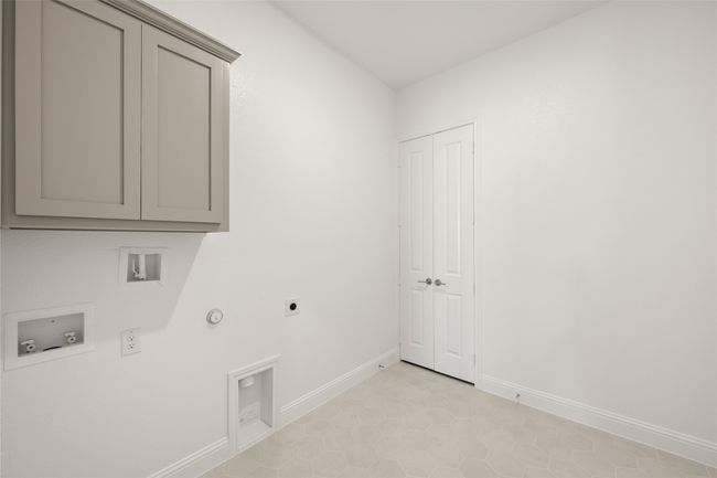 Washroom with gas dryer hookup, cabinet space, electric dryer hookup, washer hookup, and baseboards | Image 9