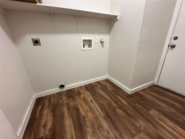 Laundry room featuring hookup for an electric dryer, dark wood-type flooring, hookup for a gas dryer, hookup for a washing machine, and a textured wall | Image 19