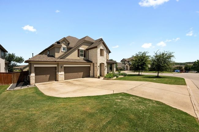 View of front facade featuring stone siding, concrete driveway, stucco siding, and an attached 3 car garage | Image 4